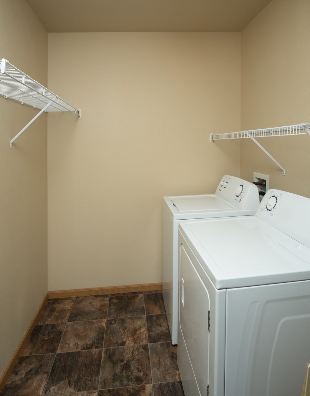 a laundry room with two washes and a dryer in it and a shelf