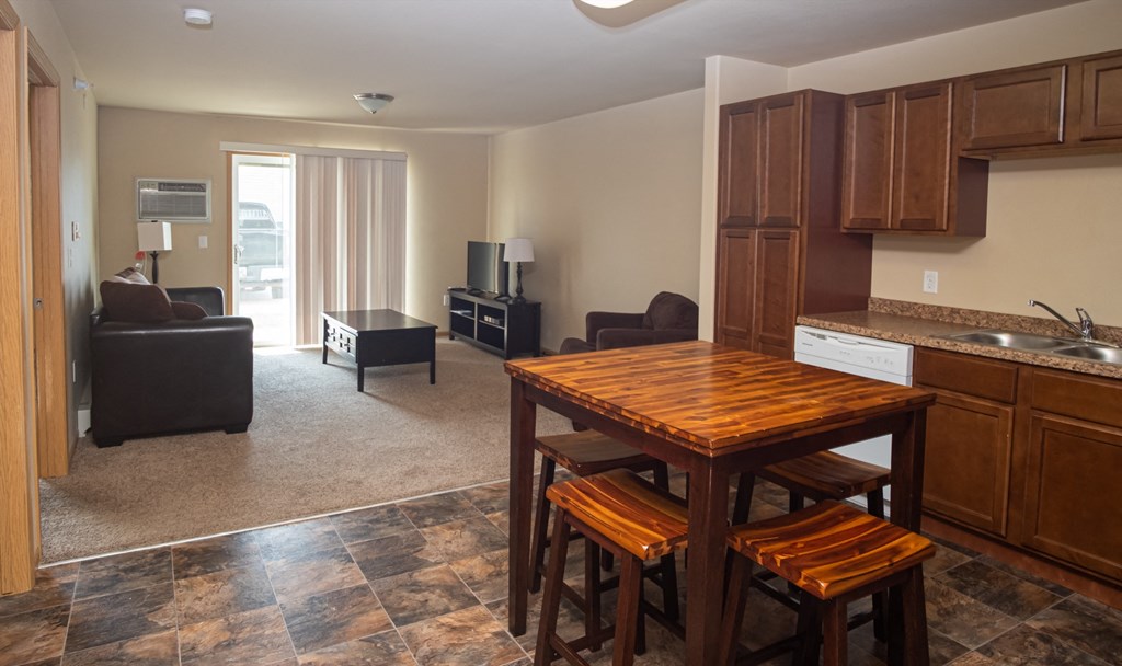 a kitchen and living room with a wooden table and chairs