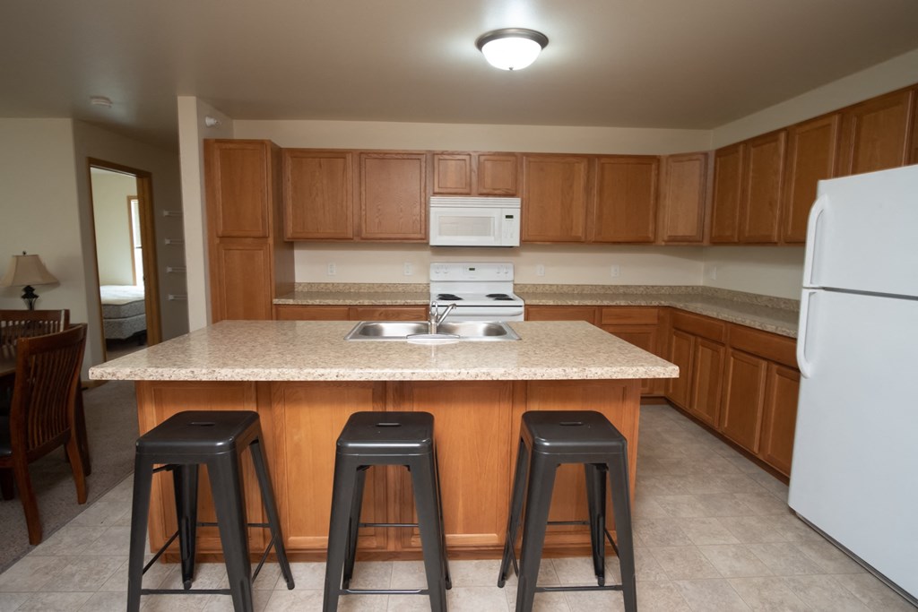 a kitchen with a marble counter top and three stools