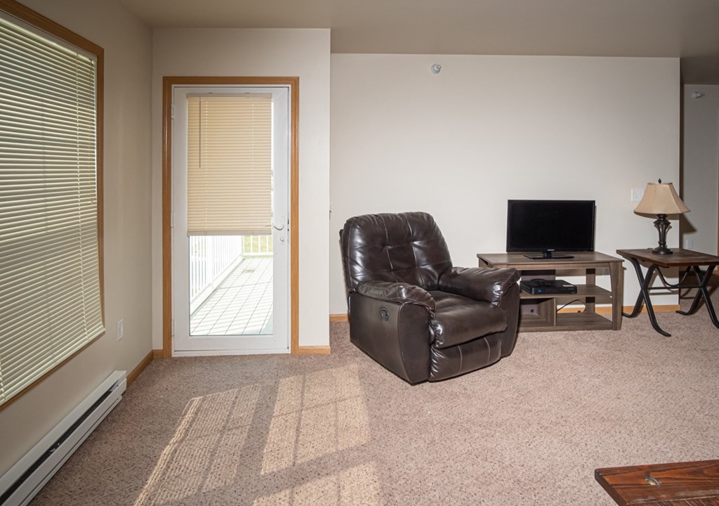 a living room with a leather chair and a tv