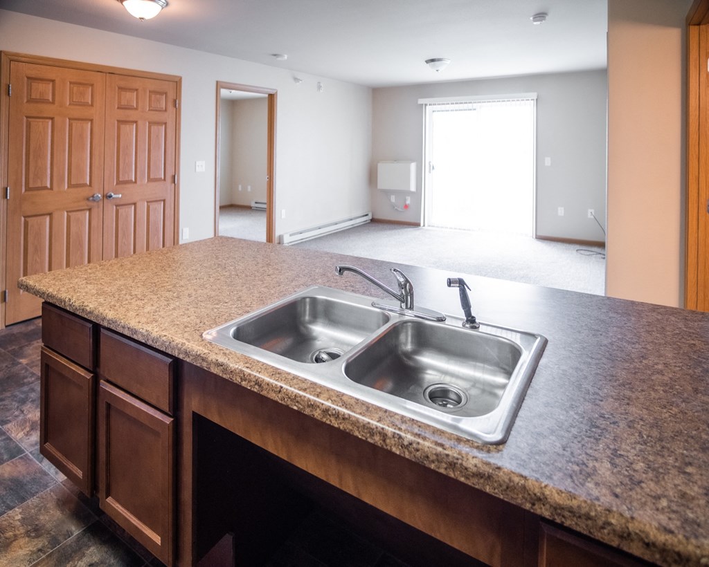 an empty kitchen with a sink in a house