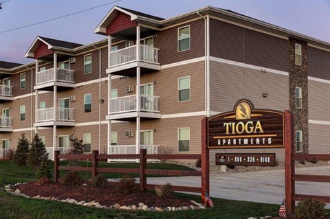 Tioga Apartments building with a sign in front.