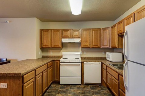 a kitchen with white appliances and wooden cabinets