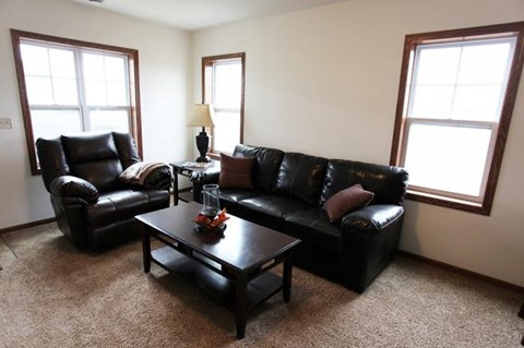 a living room with leather couches and a coffee table
