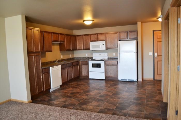 a kitchen with white appliances and wooden cabinets