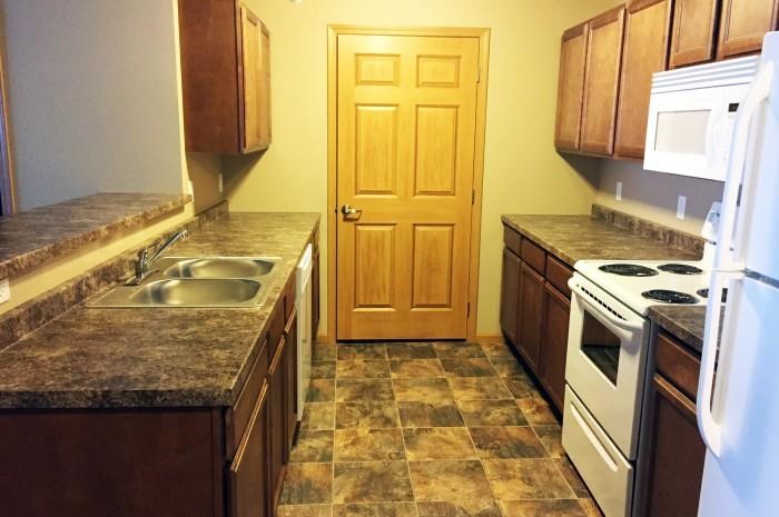 a kitchen with a stove and a sink and a door