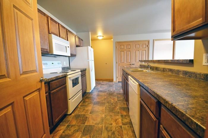 a kitchen with wooden cabinets and white appliances