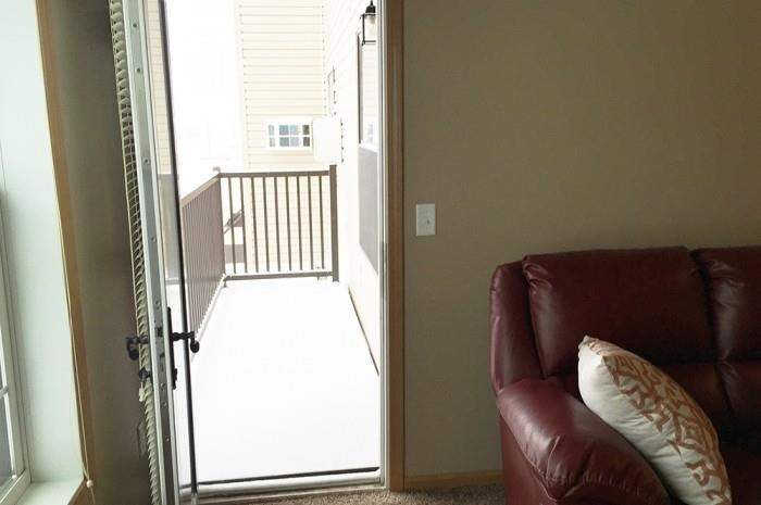 a living room with a couch and a door to a balcony