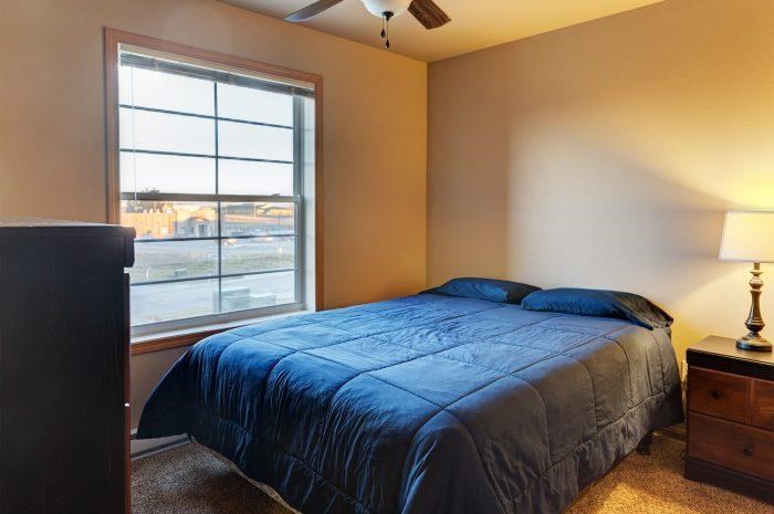 a bedroom with a bed and a large window