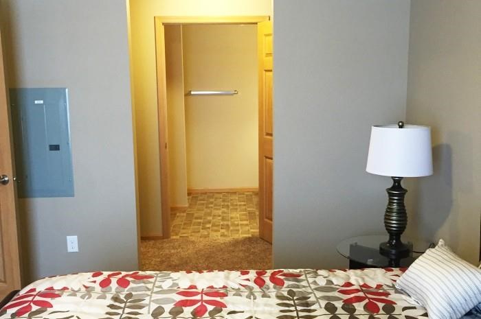 a bedroom with a bed and a lamp and a hallway