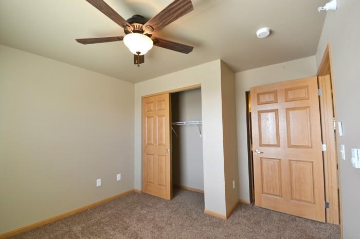 a empty room with a ceiling fan and a closet