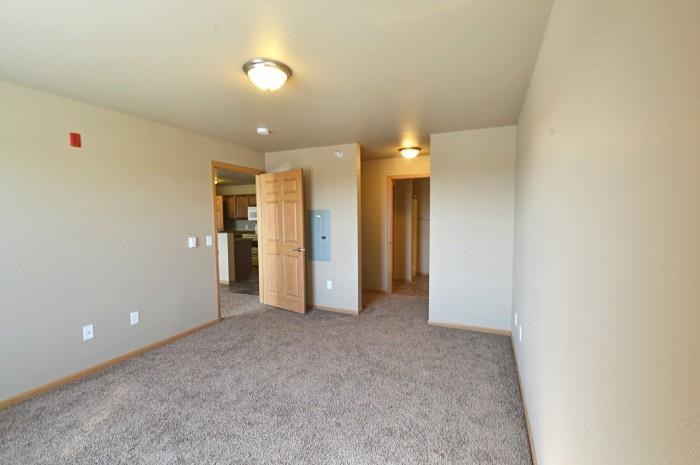 an empty living room with white walls and a carpet floor