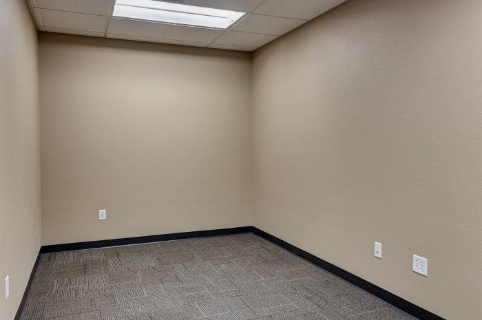 an empty room with a tile floor and a window