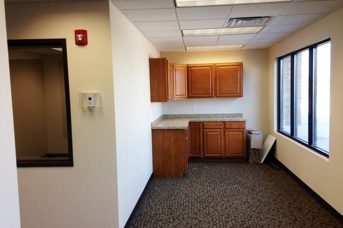 an empty room with a kitchen with wooden cabinets