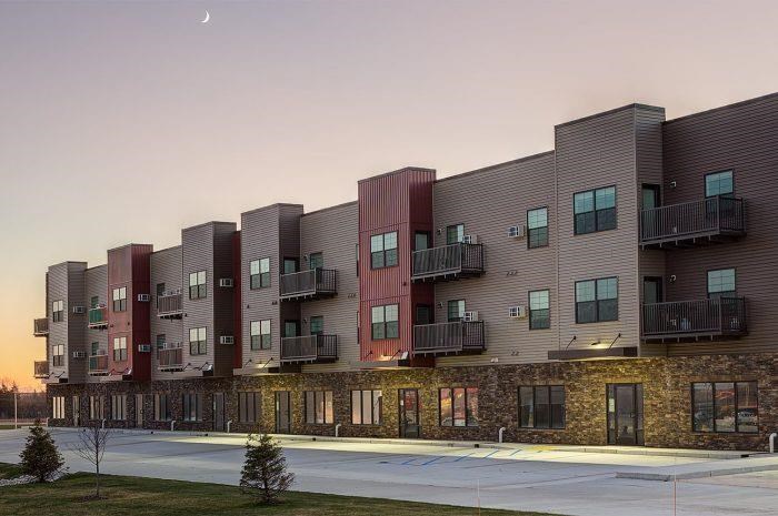 a row of apartment buildings with balconies and a sidewalk
