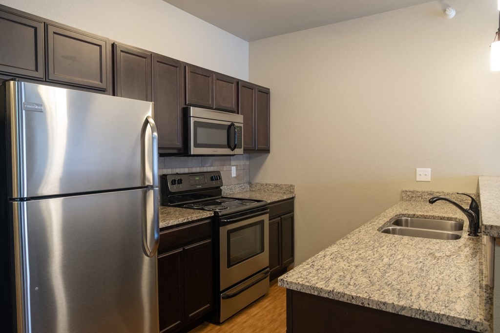 a kitchen with stainless steel appliances and granite counter tops