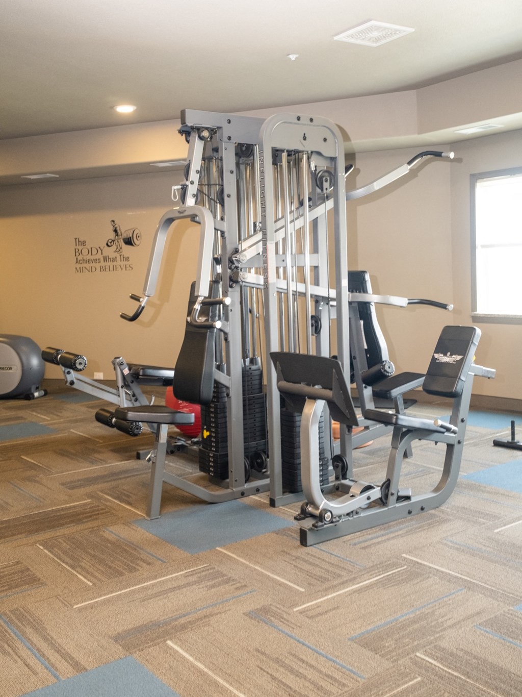 a gym with weights and cardio equipment in a building