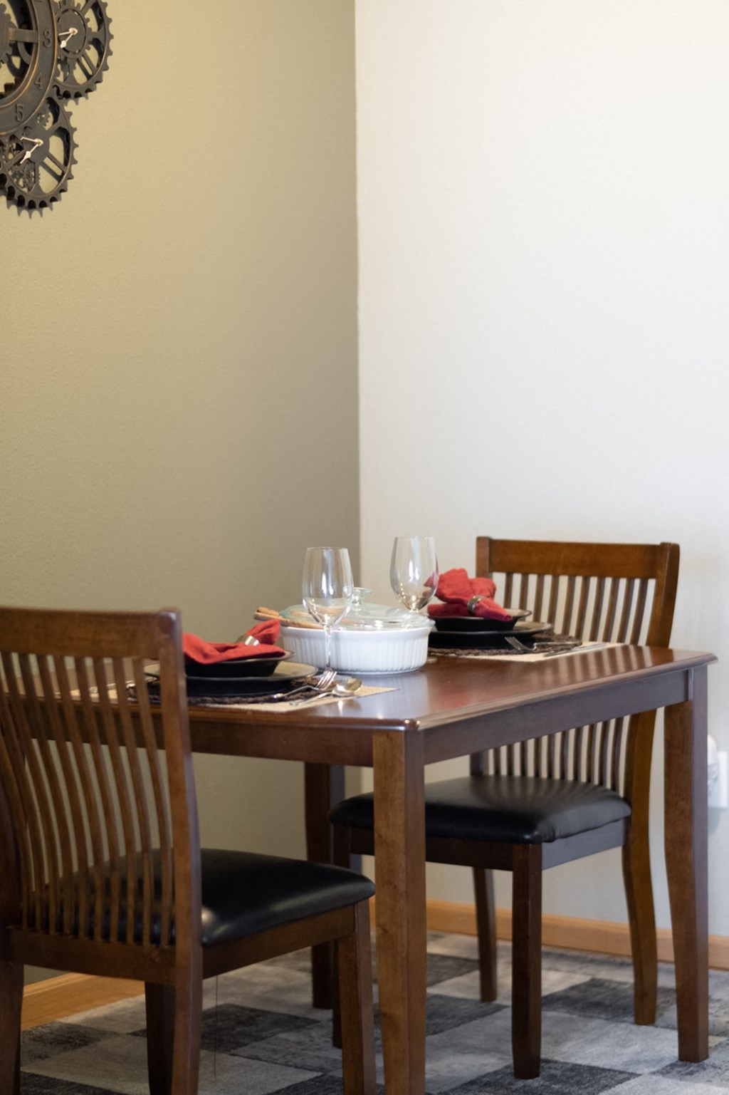 a wooden table with chairs and plates and glasses on it