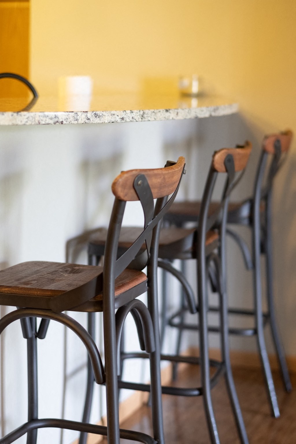 a row of bar stools under a counter at a bar