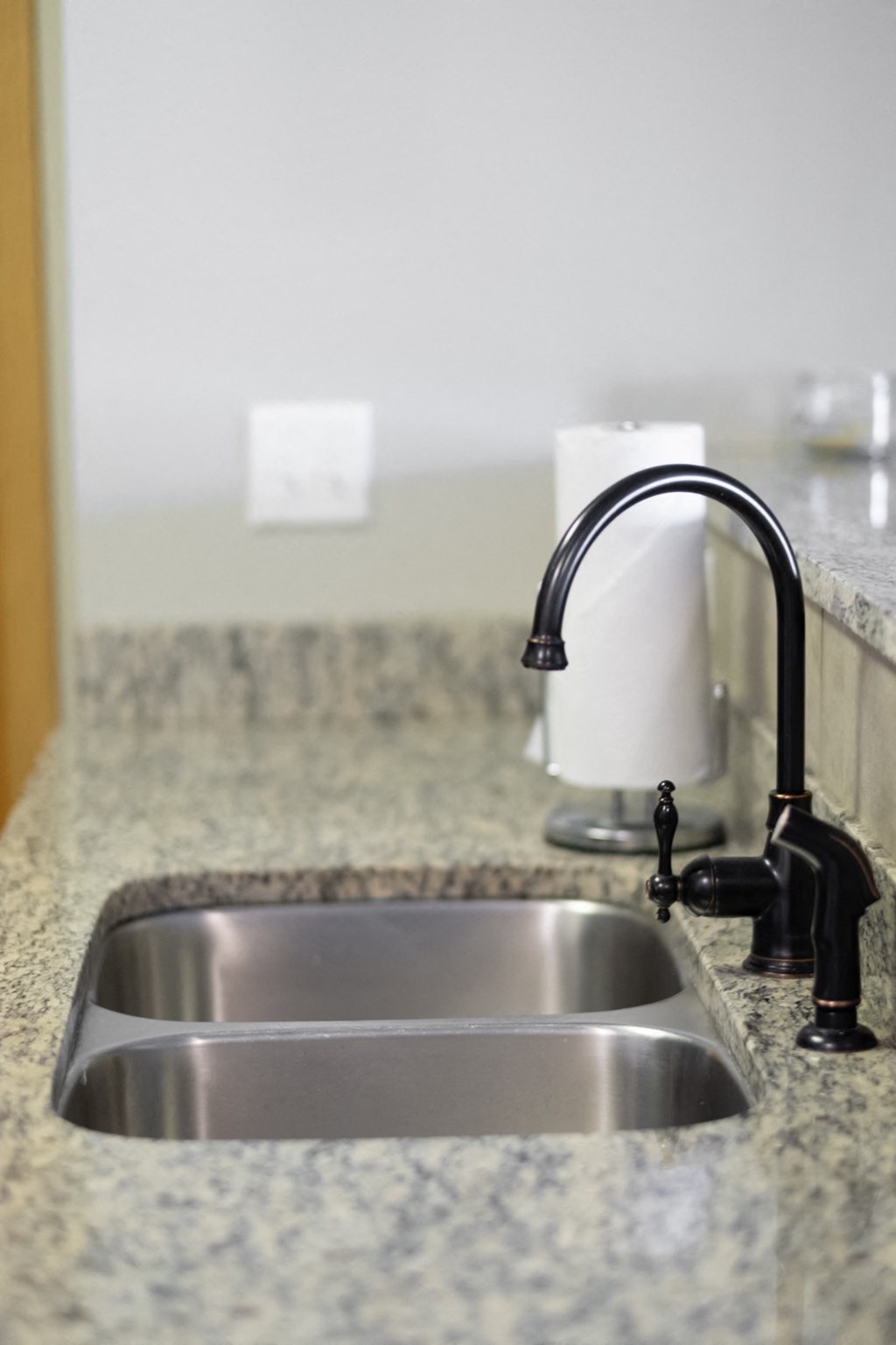 a kitchen sink with a faucet on a granite counter top