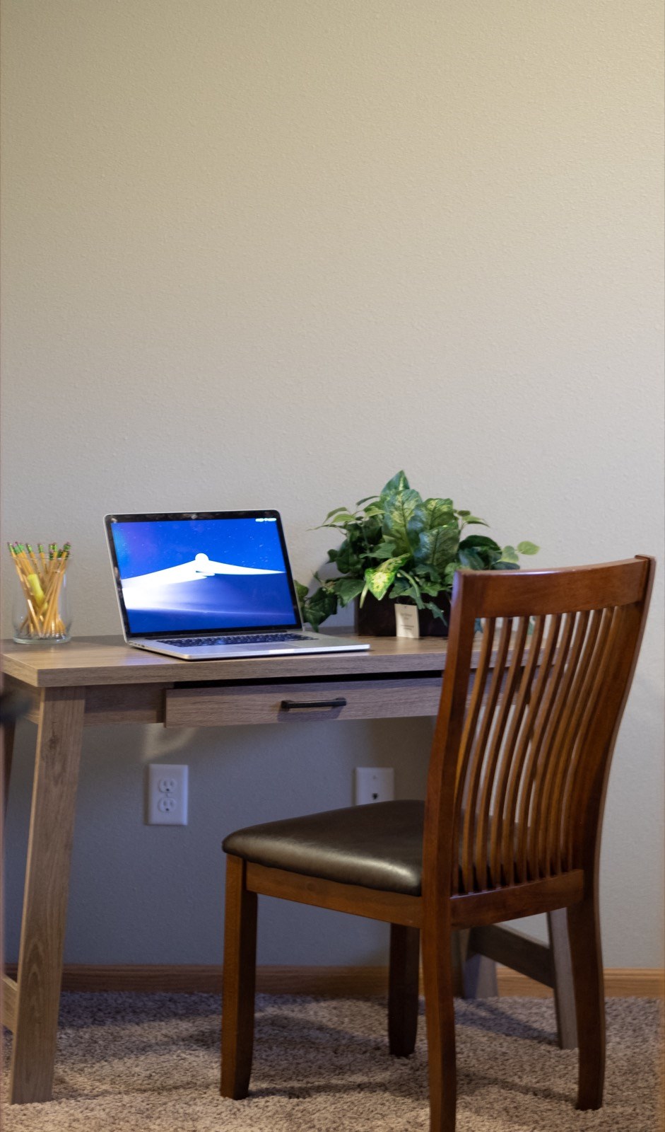 a desk with a laptop computer on it and a chair