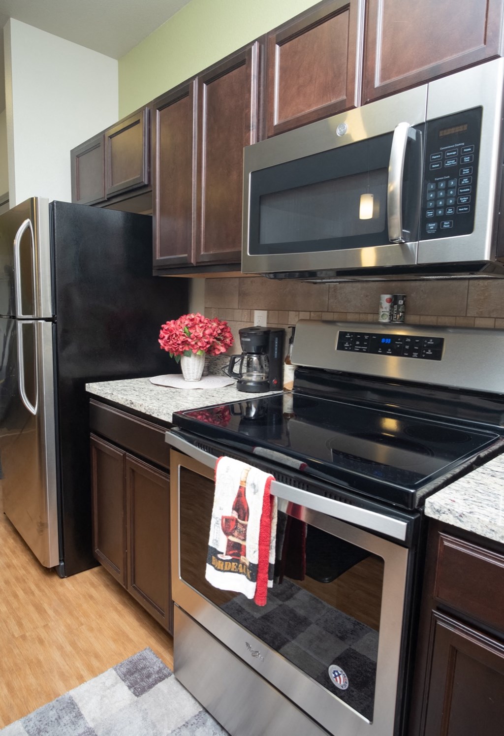 a kitchen with stainless steel appliances and a christmas towel on the stove