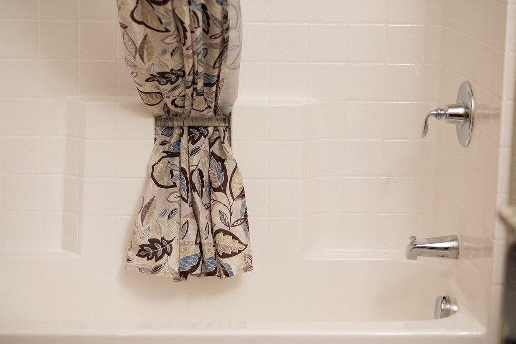 a bathroom with a towel hanging on a shower curtain