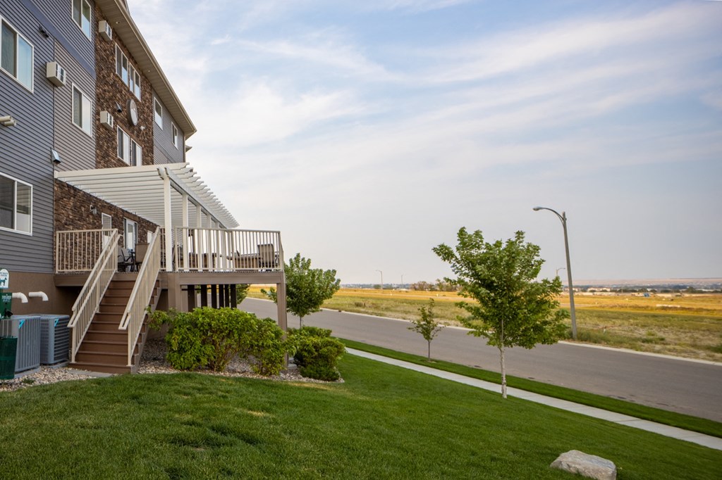 a house with a porch on the side of a road next to a field