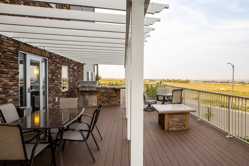 the deck has a grill and a table with chairs