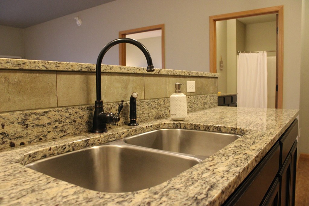 a kitchen with a sink and granite counter top