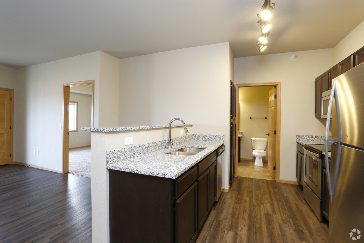 a kitchen with granite counter tops and a stainless steel refrigerator