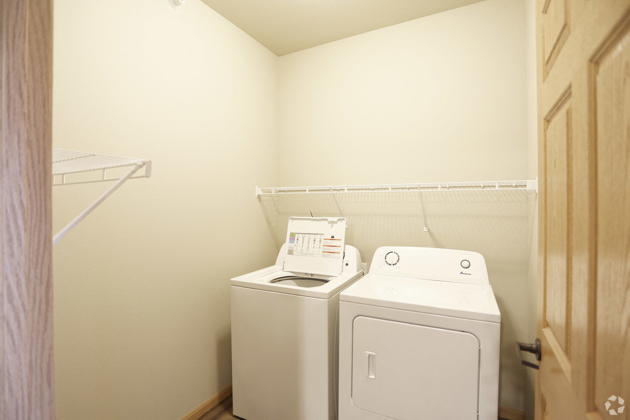 a white washer and dryer in a white room with a white laundry room