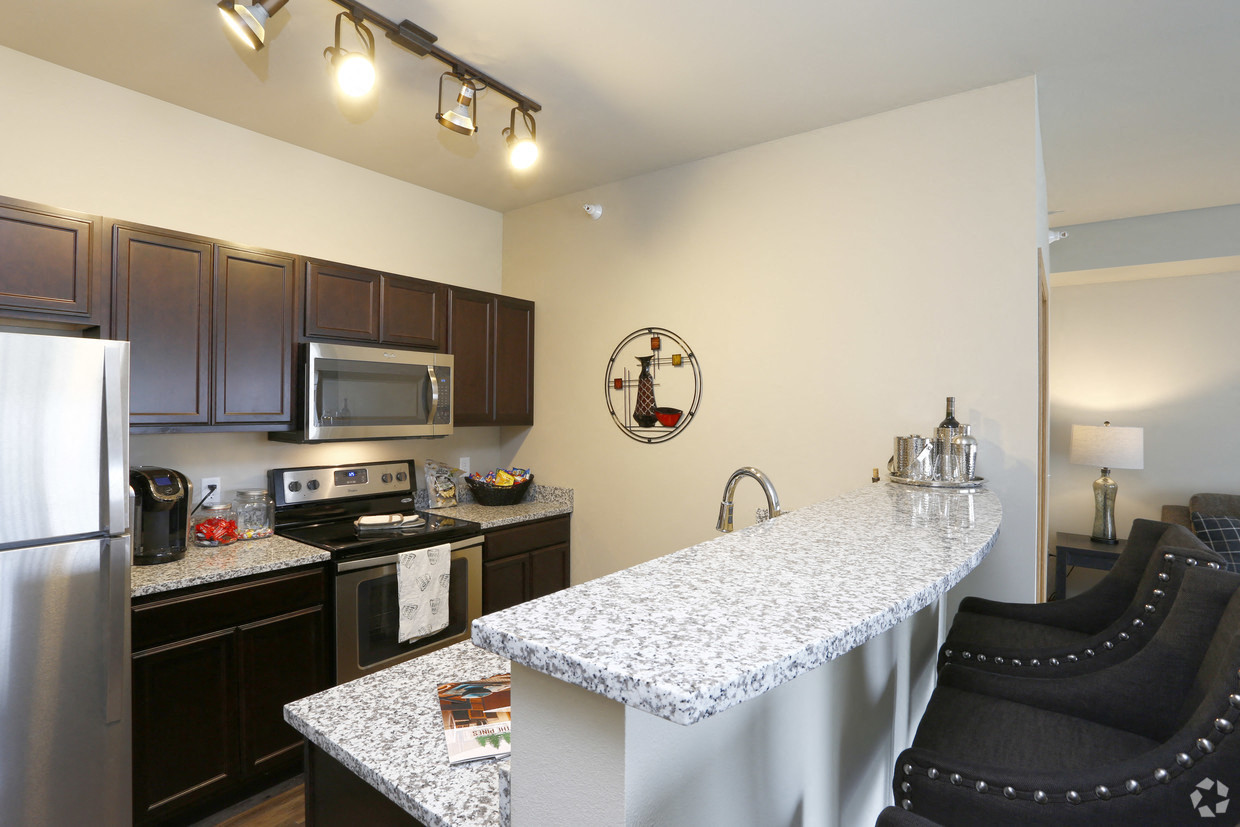 a kitchen with granite countertops and stainless steel appliances