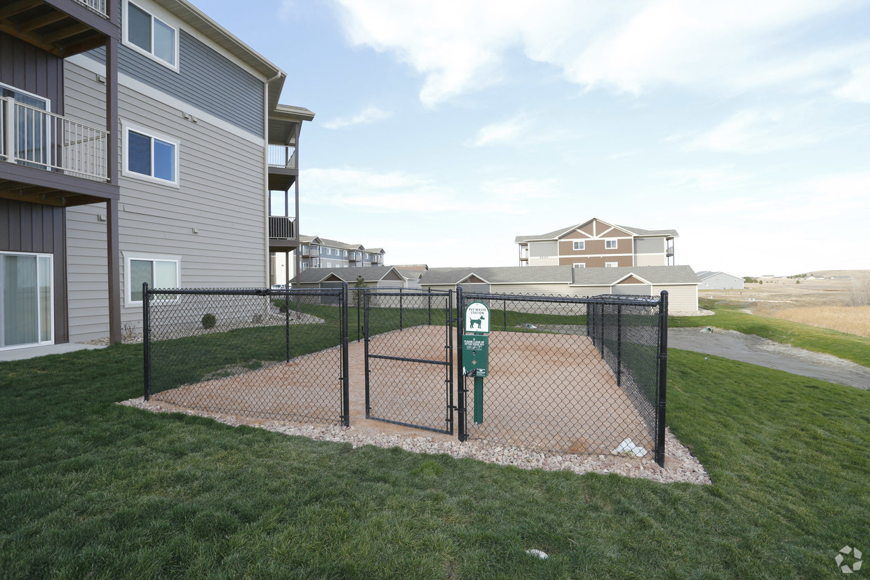 a fenced in dog park in front of a house