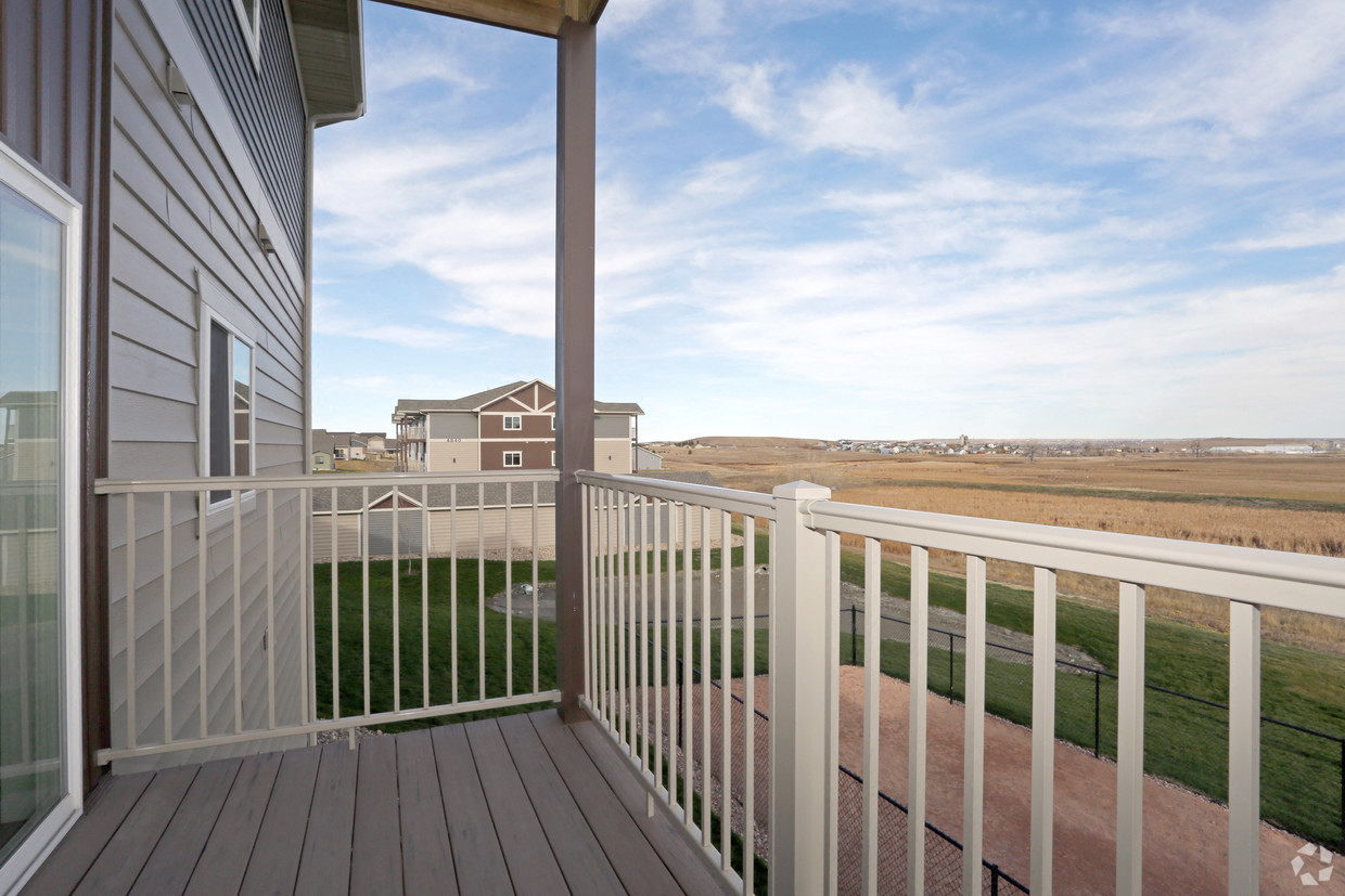 a balcony with a view of a field and a house