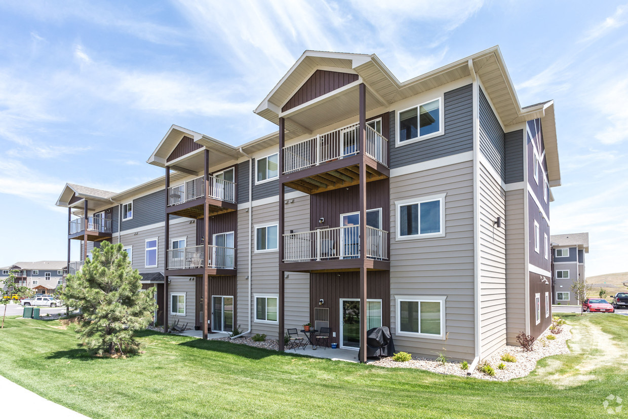 the outlook of a spacious apartment building with balconies and a lawn