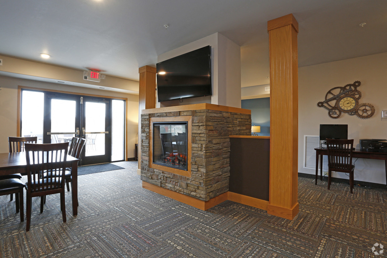 a living room with a fireplace and a table and chairs