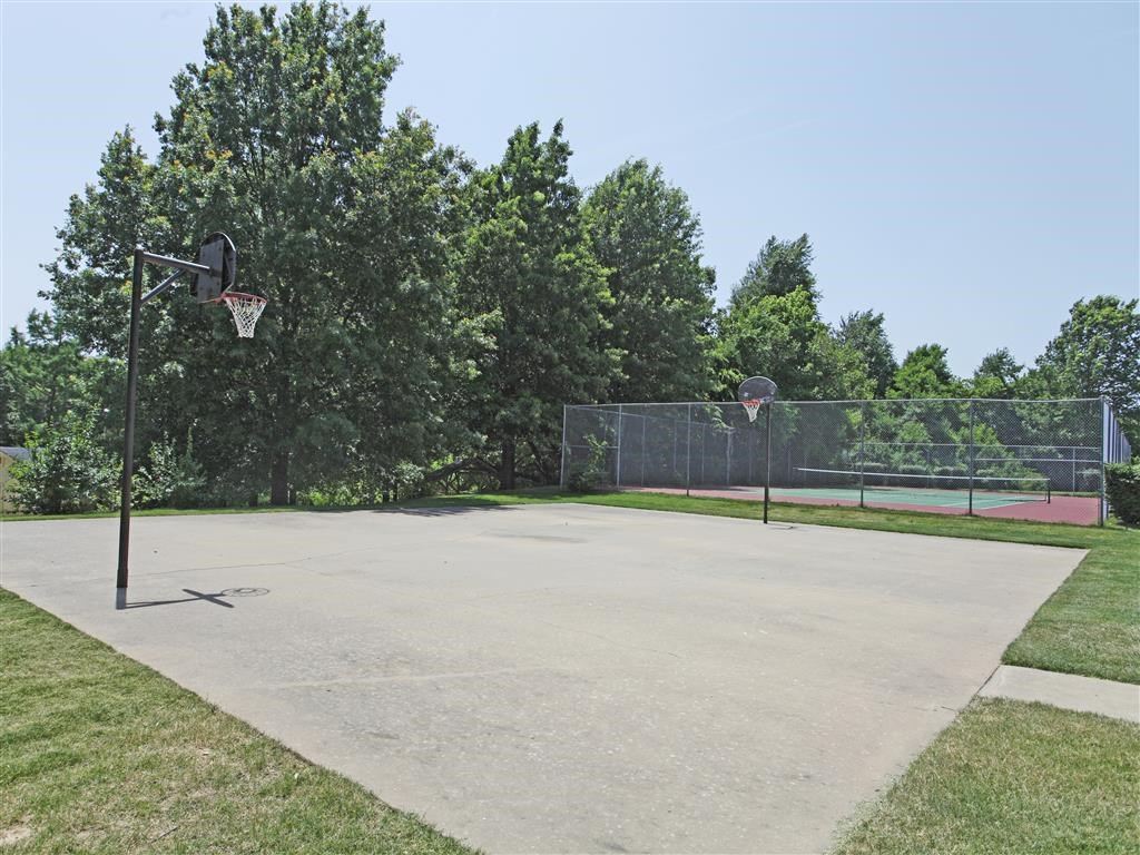 a basketball court in a park with two basketball hoops