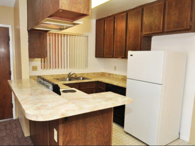 a kitchen with a white refrigerator and a sink