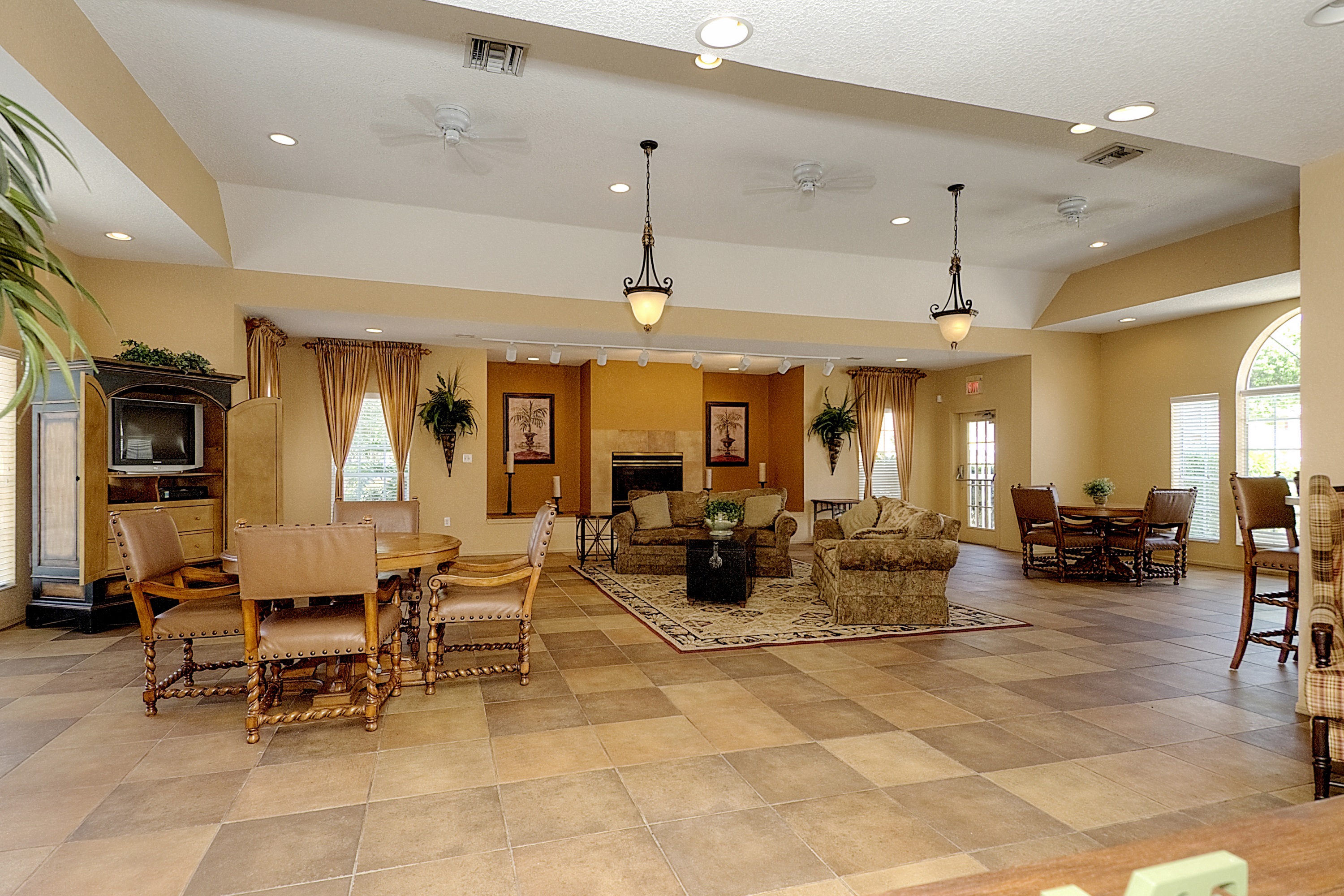 a large living room with a fireplace and a table and chairs