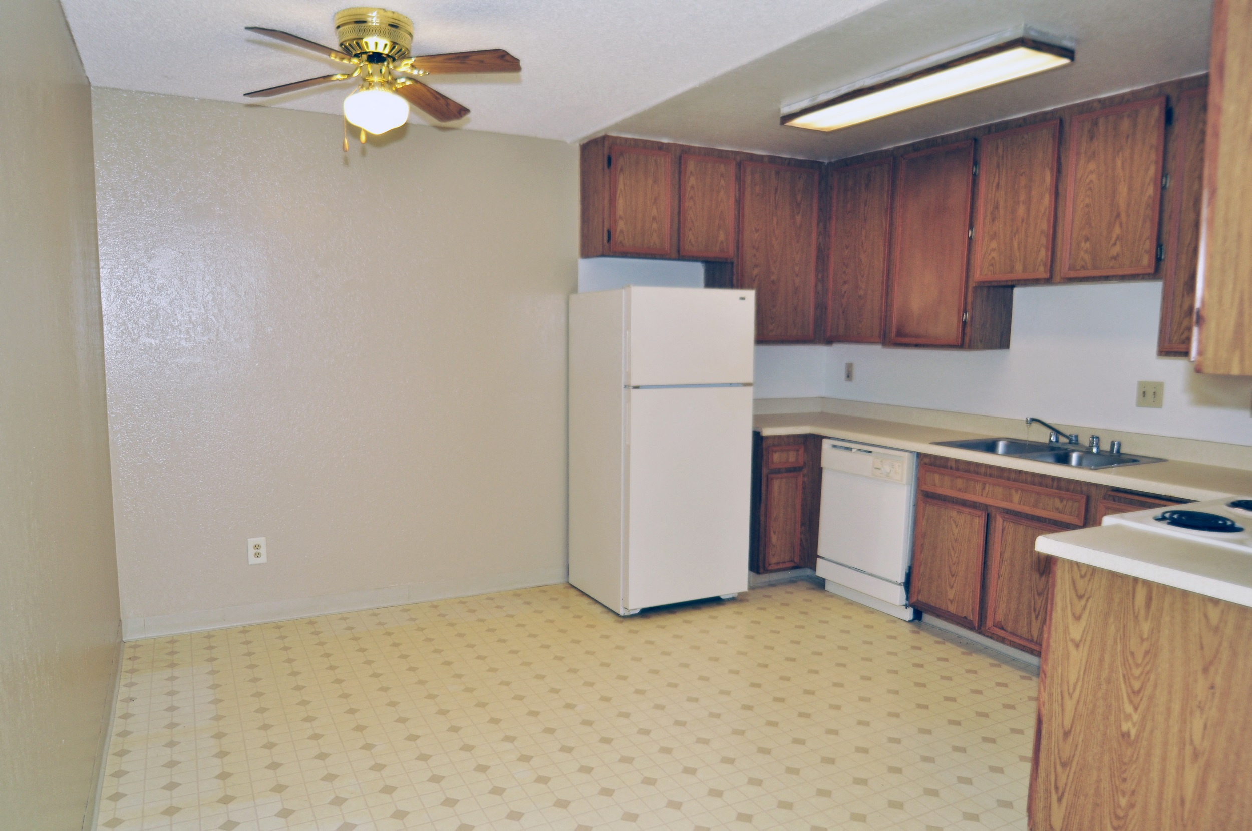 a kitchen with white appliances and wooden cabinets