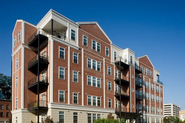 a large brick building with balconies and a blue sky