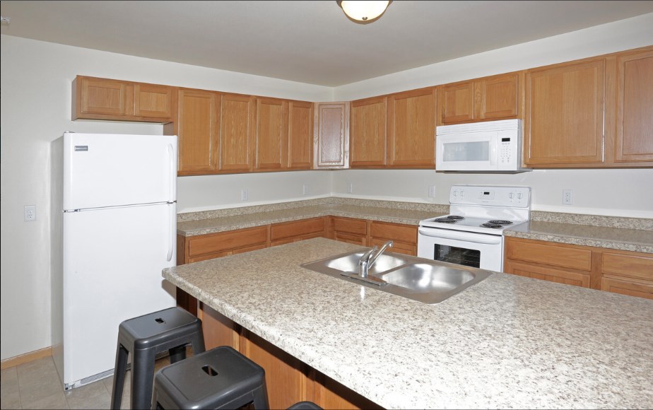 a kitchen with white appliances and a granite counter top
