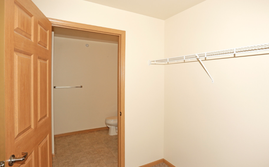 an empty room with a closet and a toilet in it