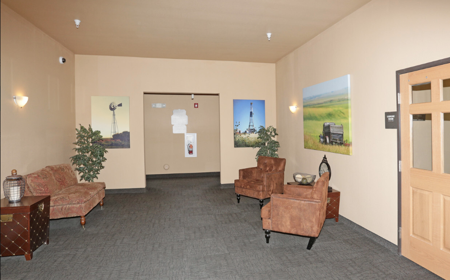 a lobby with couches and chairs and paintings on the wall