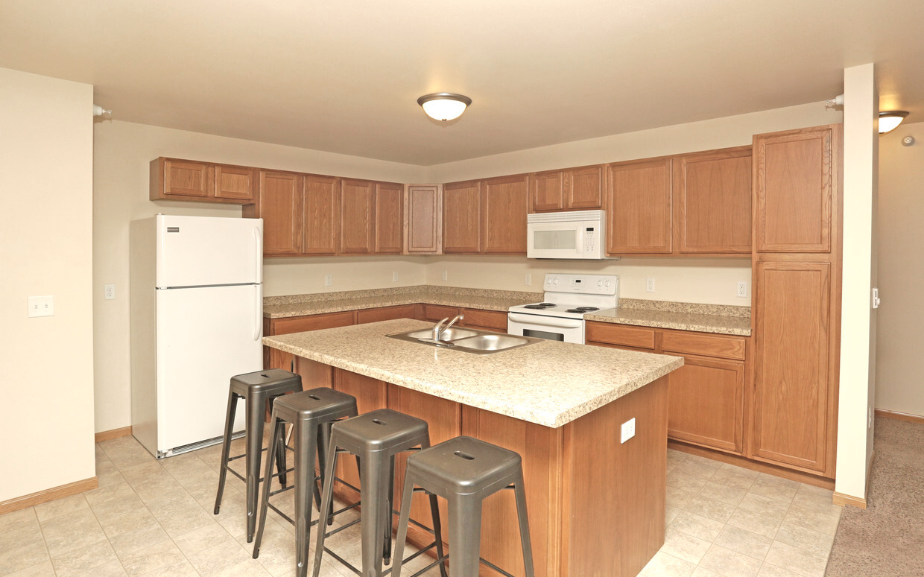 a kitchen with a large island with bar stools