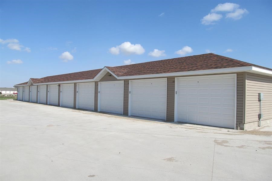 a row of garages with white doors and a roof