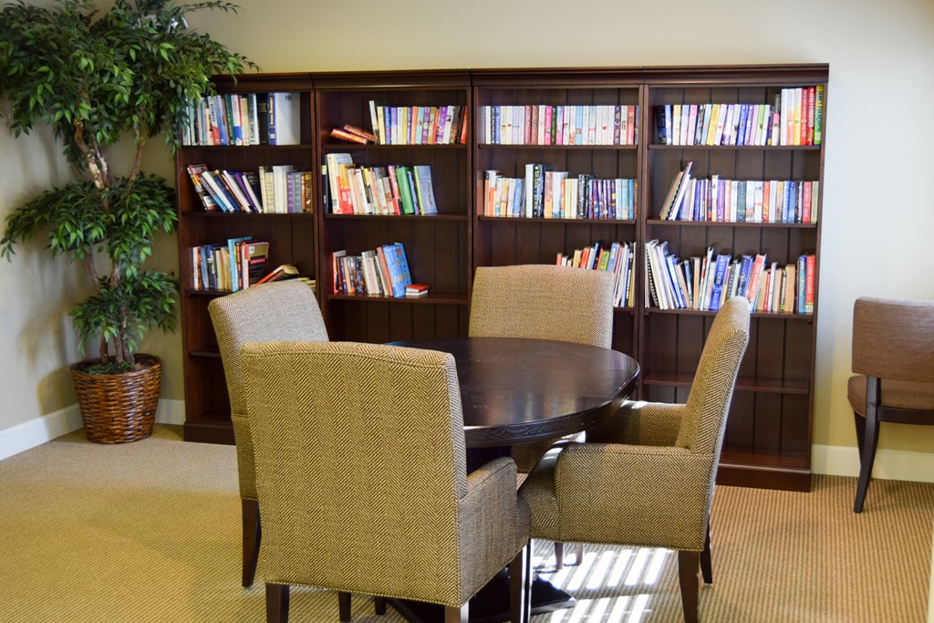 a library with a table and chairs and bookshelves