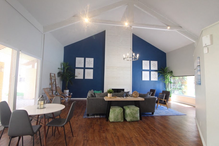 A living room with a white table and grey chairs.