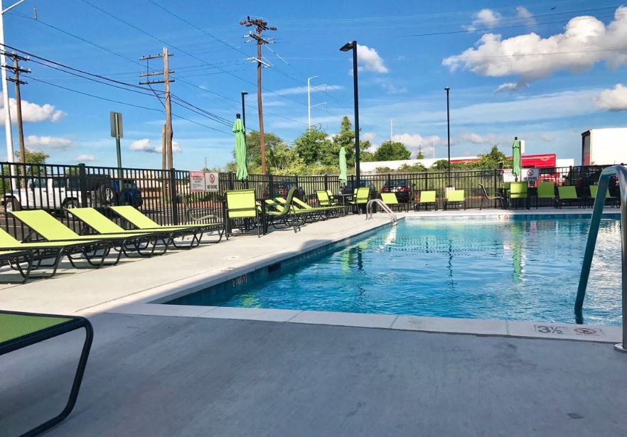 a swimming pool with yellow and green chairs around it